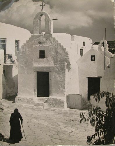 An Old Black And White Photo Of A Person Walking In Front Of A Building