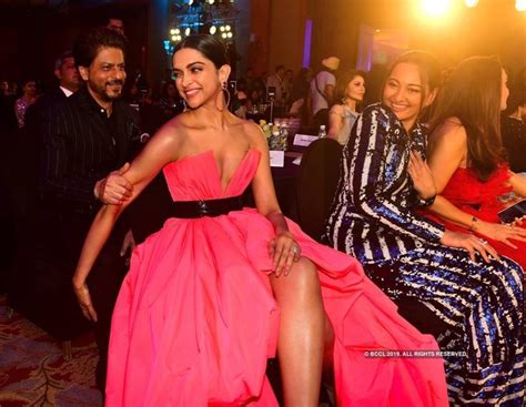 Two Women In Pink Dresses Sitting Next To Each Other At A Party With