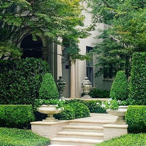 An Elegant Garden With Trimmed Hedges And Potted Plants