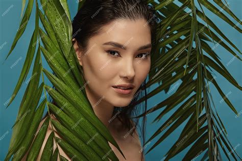 Premium Photo Asian Beautiful Girl Standing Among Tropical Plants Leaves