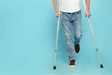 Teenage Boy Injured Leg Using Crutches Turquoise Background Stock