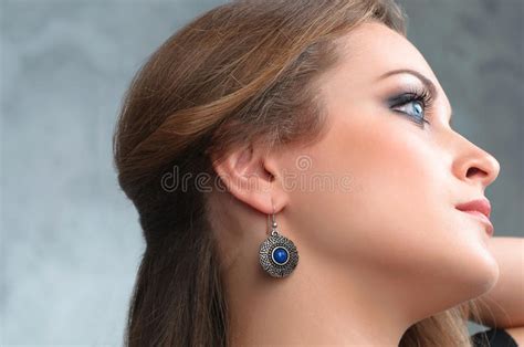 Beautiful Model Brunette With Long Hair And Jewelry Wearing Earring