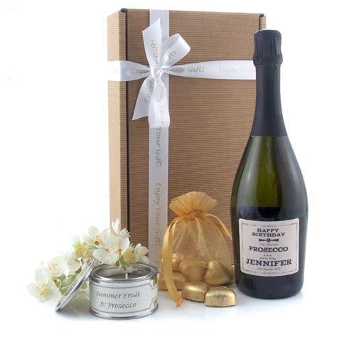A bottle of prosecco displayed with flowers, with lindor chocolates and a yankee candle in a square hat box. Birthday Prosecco and Chocolate Gifts | Prosecco Gifts