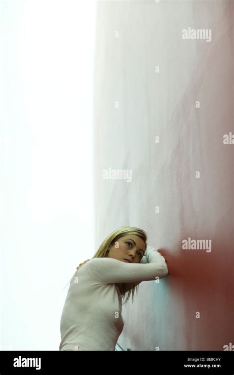 Woman Leaning Against Wall Resting Head On Arms Stock Photo Alamy