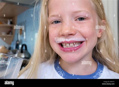 Joven Rubia Chica Caucásica Beber Leche Con Un Bigote De Leche Blanca Fotografía De Stock Alamy