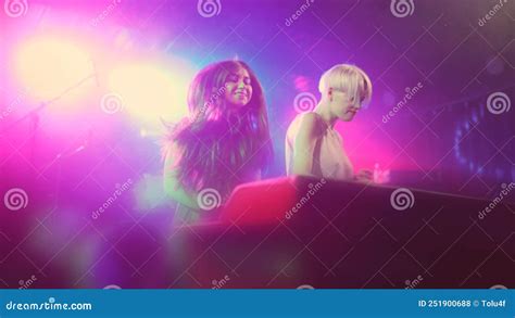 Two Beautiful Young Women Dj Play The Music On The Mixing Console In