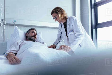 Hospitalized Man Lying In Bed While Doctor Checking His Pulse Female