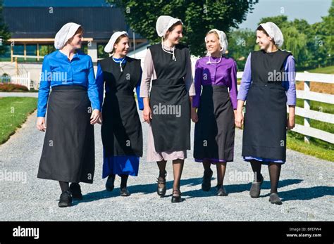 Young Amish Women Friends Walking Down Country Lane Road In Lancaster