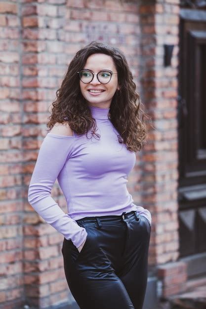 Premium Photo A Woman In A Purple Top And Black Pants Stands In Front