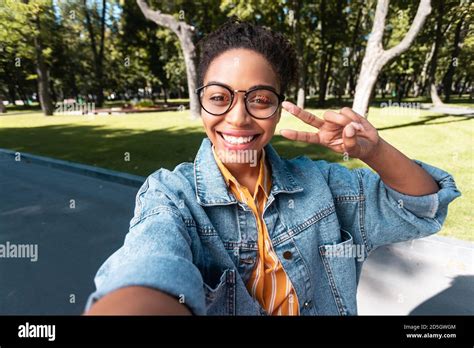 Cheerful Black Female Student Making Selfie Gesturing V Sign Outside