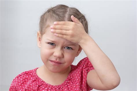 Premium Photo Child With Headache Holding Hand On Forehead