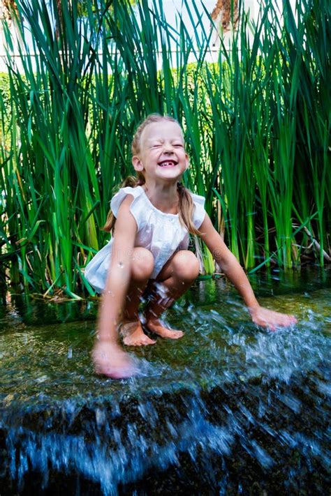 Junge Und Mädchen Die Im Wasser Nahe Kleinem Wasserfall Sitzen Stockfoto Bild Von Glück