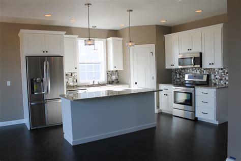 A black and white kitchen by studio surface, an interior design firm out of del mar, california gets a functional lift from a narrow, stainless steel chef's table.the handy piece of furniture makes an excellent kitchen island at a fraction of the cost. The Best of White Cabinets! - Katie Jane Interiors