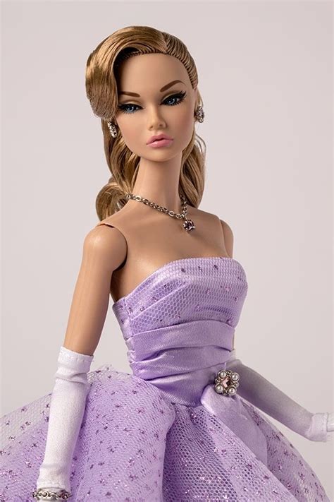 A Barbie Doll Wearing A Purple Dress And White Gloves With Pearls On It S Head