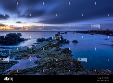 Twilight Begins Yielding To Daylight At Rocky Coastline Stock Photo Alamy