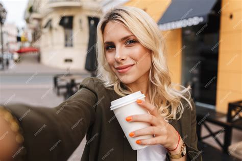 Premium Photo Image Of Pleased Woman Holding Takeaway Coffee In Paper