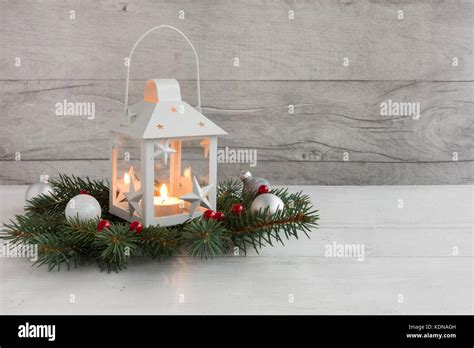 White Christmas Lantern With Lit Candle On Fir Tree Twigs Decorated
