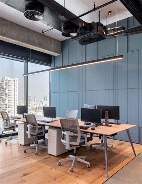 An Office With Multiple Desks And Chairs In Front Of Large Windows