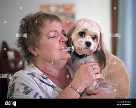 A Woman Holds Her Dog In Her Arms Stock Photo Alamy