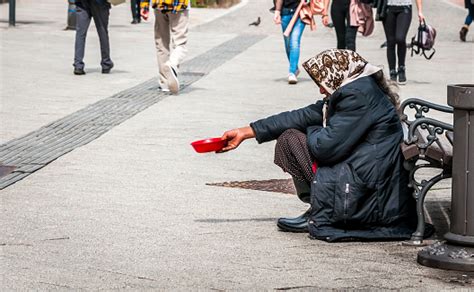 Hungry Homeless Beggar Woman Beg For Money On The Urban Street In The City From People Walking