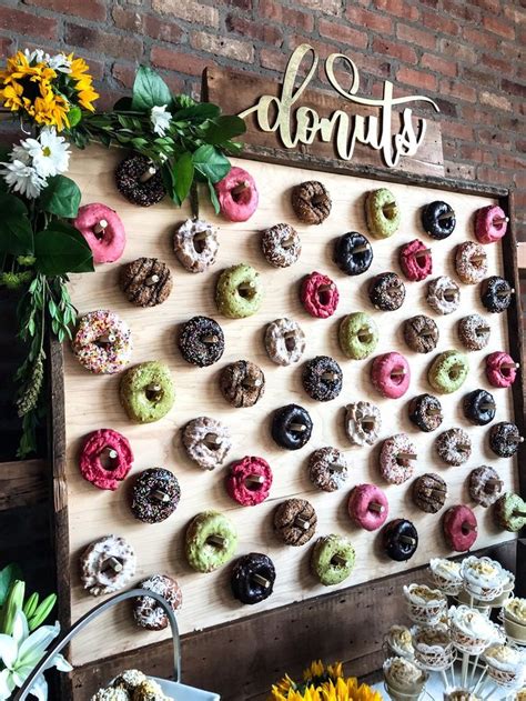 a wooden board with doughnuts on it next to sunflowers and flowers