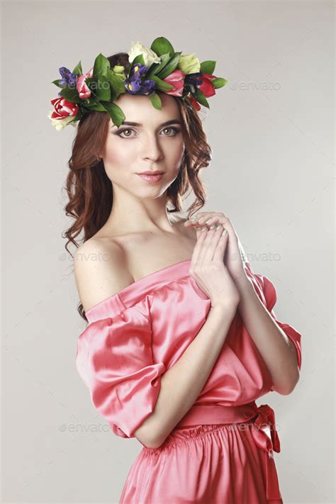 gentle romantic appearance of the girl with a wreath of roses on her head and a pink dress