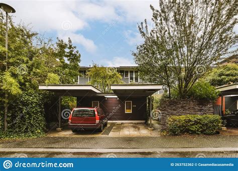 A House With A Red Car Parked In The Driveway Editorial Photography