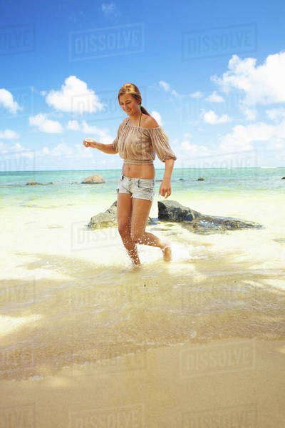 A Young Woman Runs In The Shallow Water On Anini Beachkauai Hawaii United States Of America