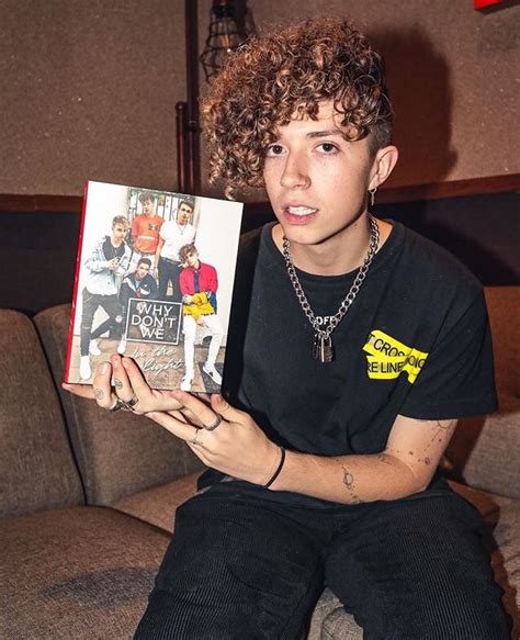 A Person Sitting On A Couch With A Book In Their Hand And An Album In