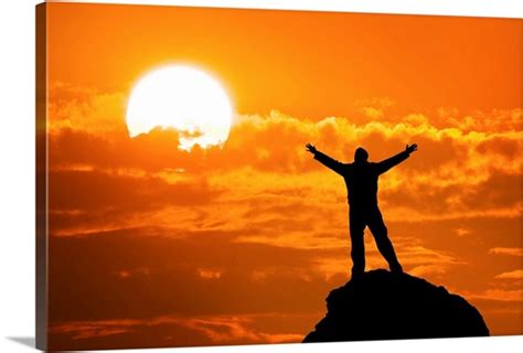 Silhouette Of Man On Mountain Peak With Arms Outstretched