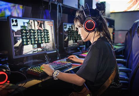 Young Girl Playing Computer Games In Internet Cafe Stock Photo