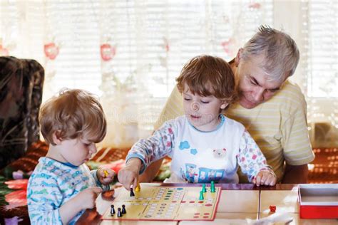 Two Little Sibling Boys Playing Grandfather Board Game Stock Photos