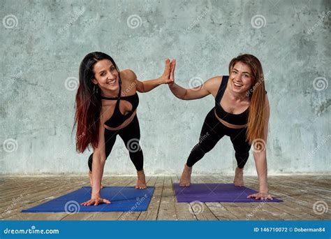 Two Smiling Beautiful Fitness Girls Doing Exercises In The Fitness Room Give Five Concept