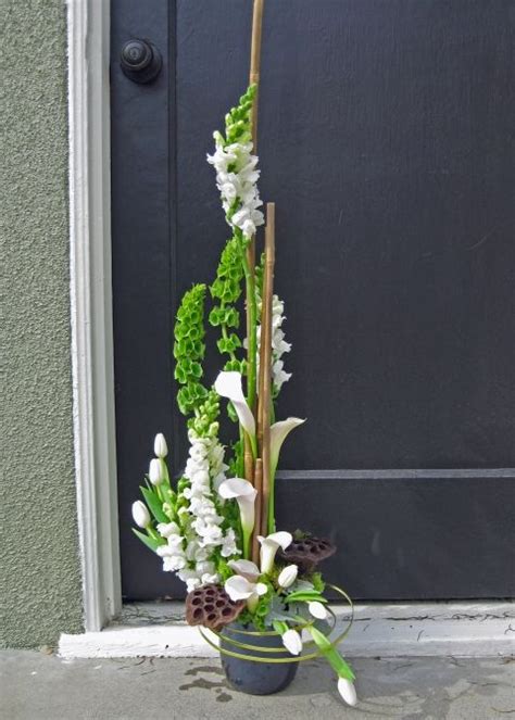 Flower arranging is the art of organizing the design elements of plant material and other components according to artistic principles to achieve beauty, harmony, distinction, and expression. Vertical sculpture arrangement. Beautiful altar ...
