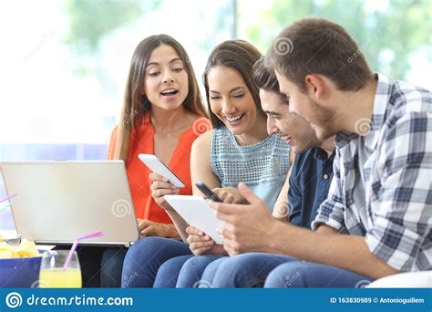 Four Happy Friends Checking Multiple Devices At Home Stock Image