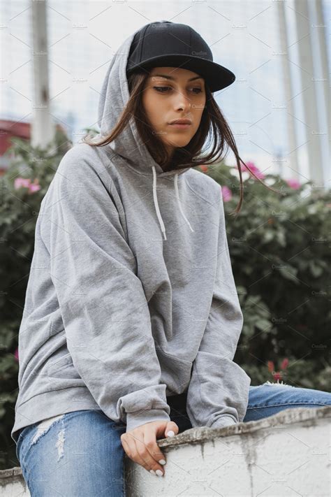 Young Girl Wearing Hoodie Featuring Background Woman And Fashion