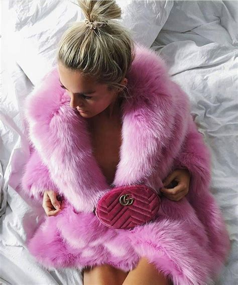 Pink Is The New Black A Stunning Model Sitting On The Bed Wearing A Beautiful Pink Fox Fur Coat