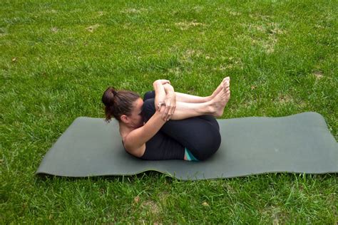 Flexible Woman Doing Knee To Chest Stretch Outside