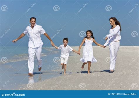 Familia Con Los Niños Que Se Ejecutan Divirtiéndose En La Playa Fotos