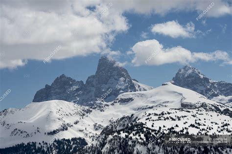 Rugged Mountain Peaks On A Landscape Covered In Snow With Blue Sky And