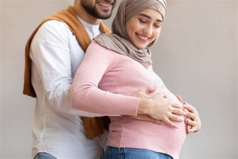 Happy Arab Husband Hugging Pregnant Wifeand X27 S Belly On Gray Background Stock Image Image Of
