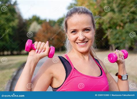 Beautiful Mature Blonde Woman Working Out With Dumbbells After Running At The Park On A Sunny