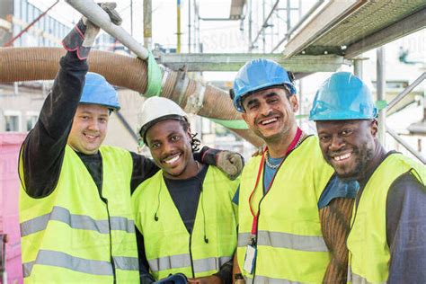 Portrait Of Happy Construction Workers Standing Together At Site