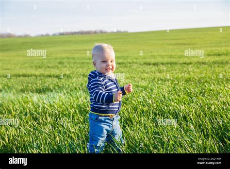 Beautiful Baby Boy Standing In The Green Grass Stock Photo Alamy