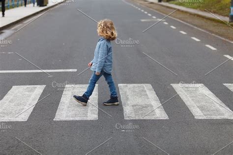 Little Boy Crossing On The Road Containing Road Pedestrian And Street