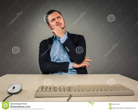 Handsome Man Sitting At A Desk And Looking Up Stock Photo Image Of