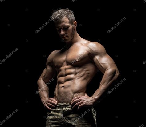 Muscular Athlete Bodybuilder Man On A Dark Background Stock Photo By Bondarchik