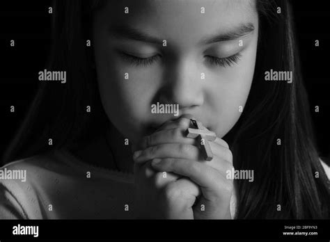 Black And White Portrait Of Cute Little Asian Girl Praying On Dark Background Closeup Stock