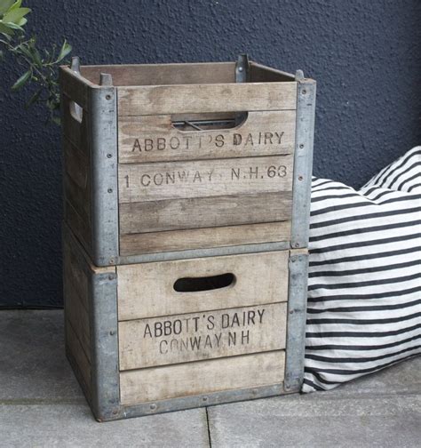 An Old Wooden Crate Sitting On The Ground Next To A Striped Pillow And