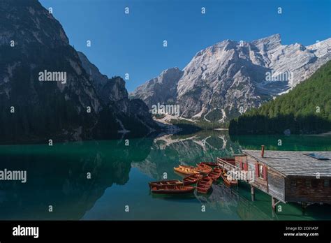 The Seekofel Mountains And Wooden Boats Reflected In The Waters Of Lake